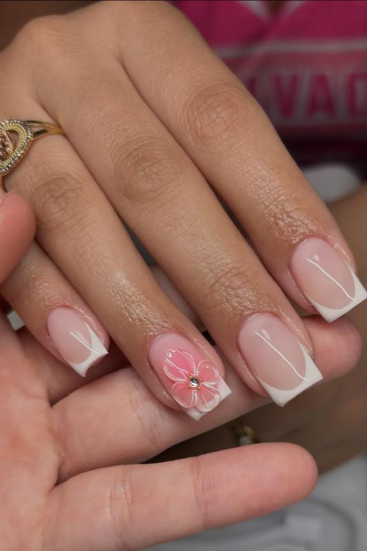 Natürliche rosa Basis mit weißen Spitzen und pinkem Blumenmuster auf dem Ringfinger, verziert mit einem kleinen Stein.