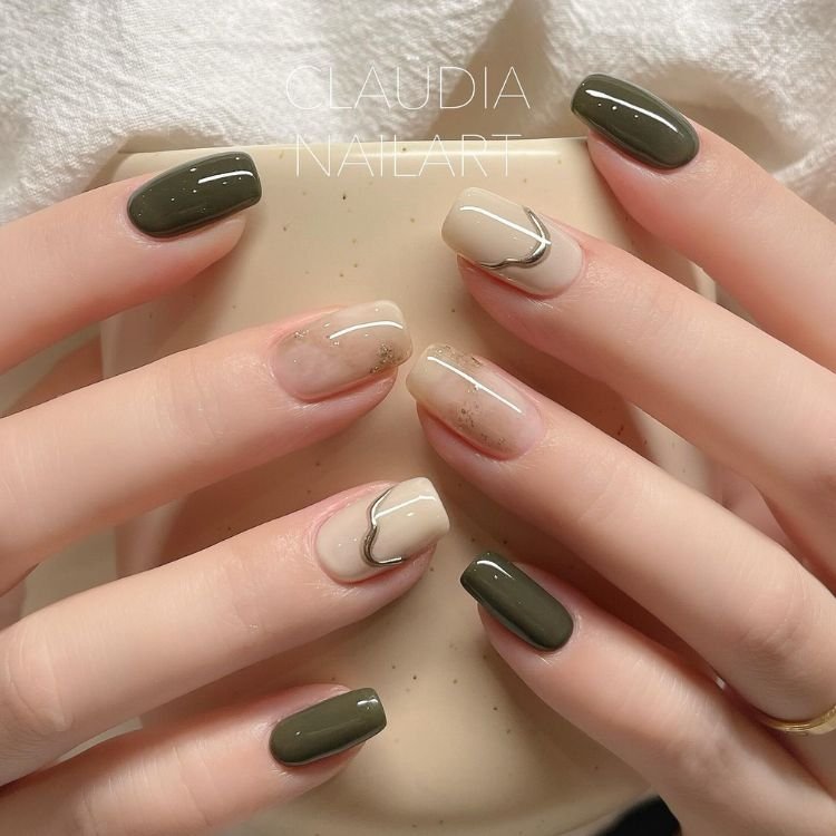 Elegantes Nageldesign mit olivgrünen und beigen Nägeln, akzentuiert durch silberne Herzlinien.