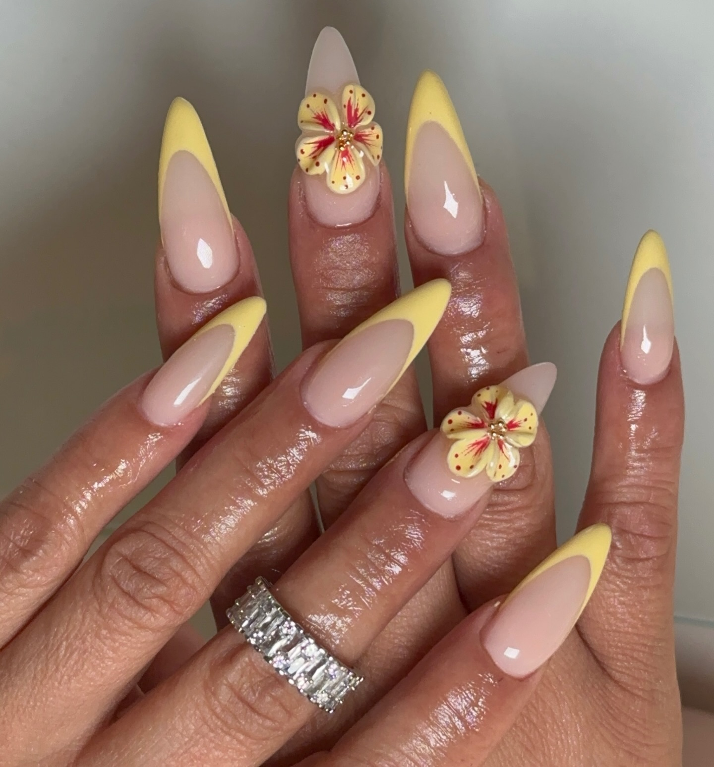 Gelbe French Tips mit zarten 3D-Blüten.