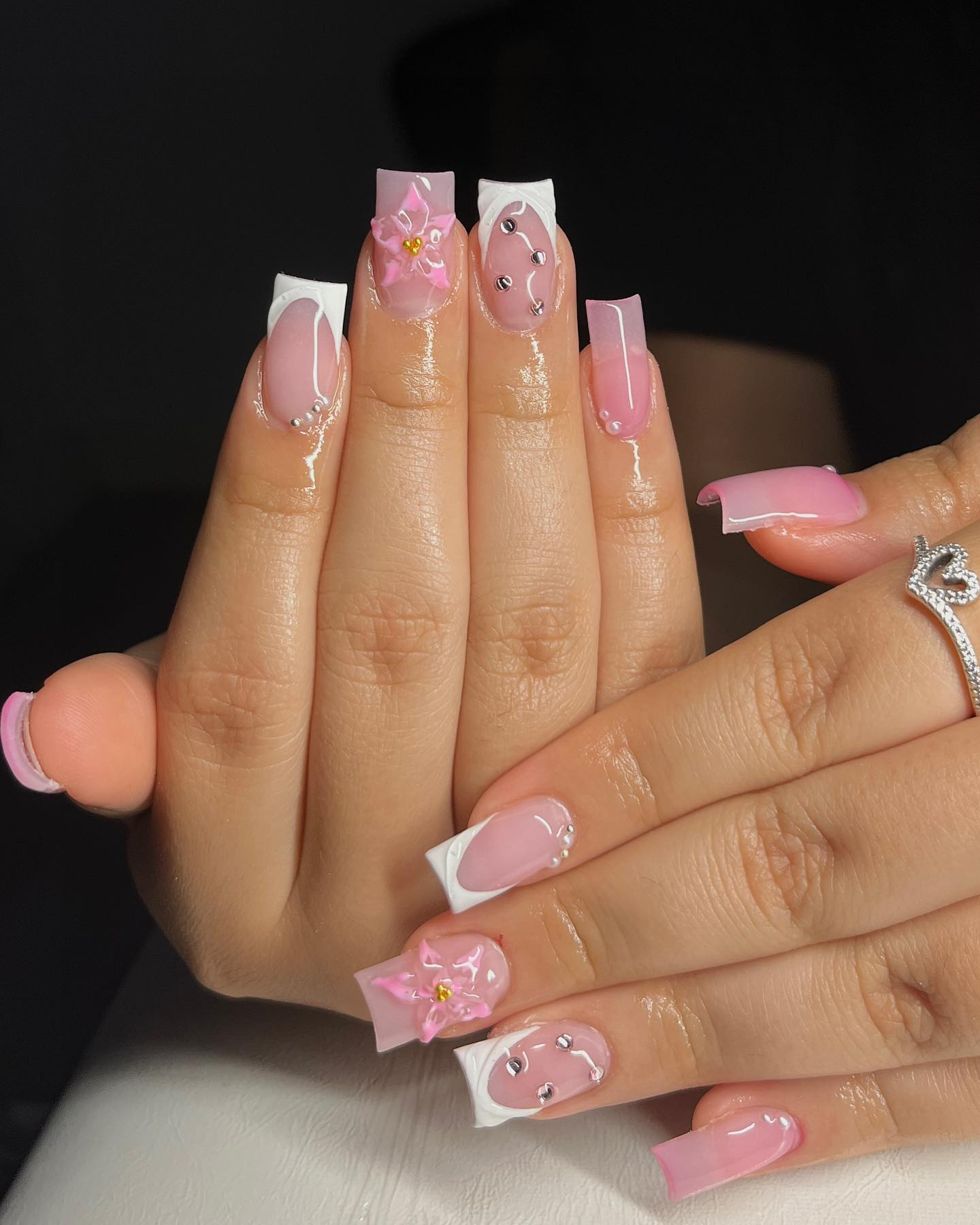 Elegantes, pinkes Nageldesign mit weißen Spitzen und 3D-Blüten.