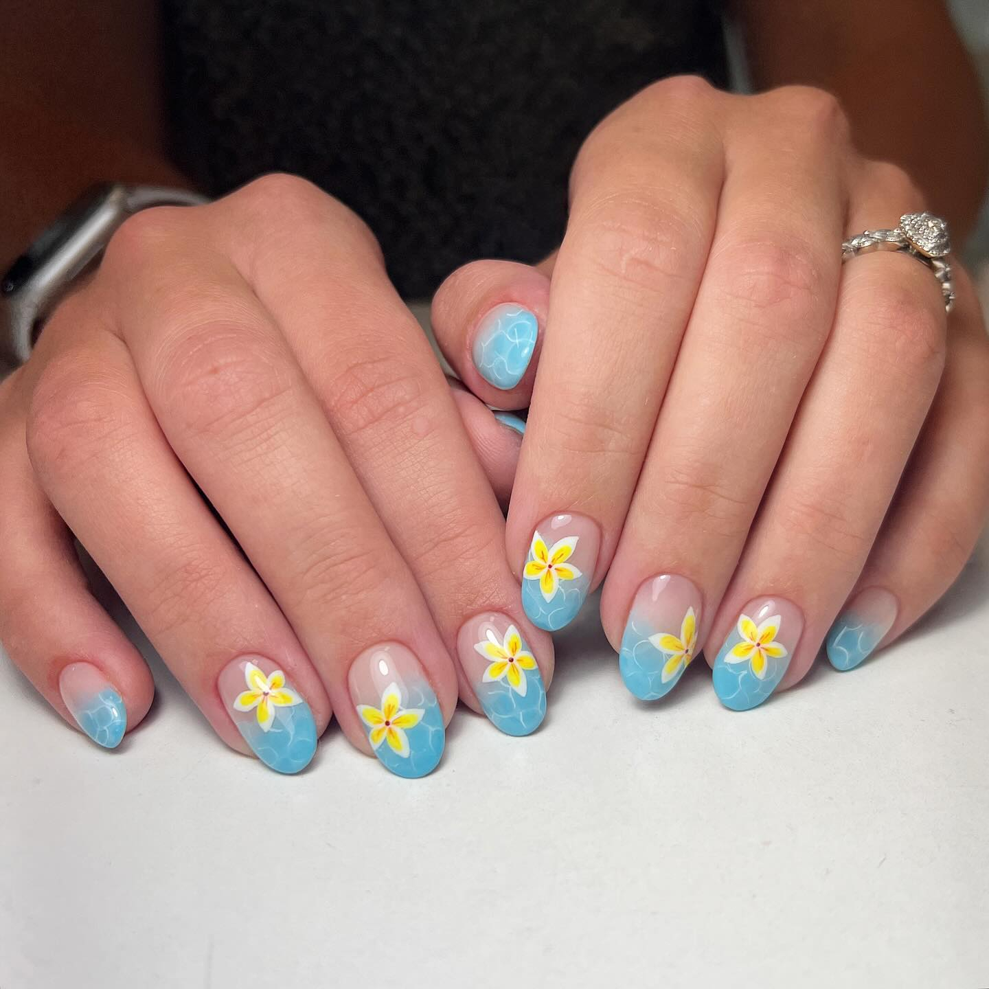 Hellblaue Nägel mit gelben Blüten und Ombré-Effekt