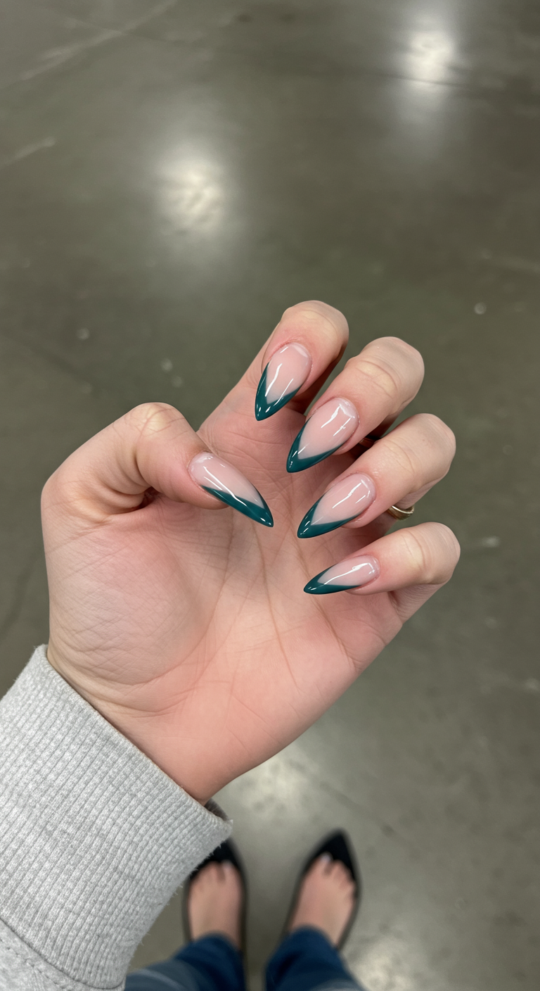 Stiletto-Nägel mit tiefgrünen V-förmigen French-Tips.
